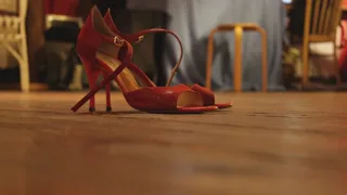 Paire de sandales à talons rouges posée sur un parquet en bois chaleureux