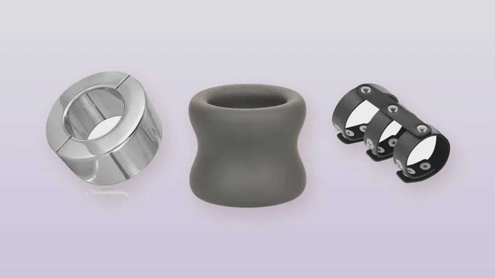 Trois anneaux pour testicules : acier poli, silicone gris et cuir noir à pressions, sur fond lavande