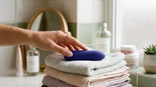 Vibro bullet violet, mini vibromasseur clitoridien discret, posé sur des serviettes de salle de bain