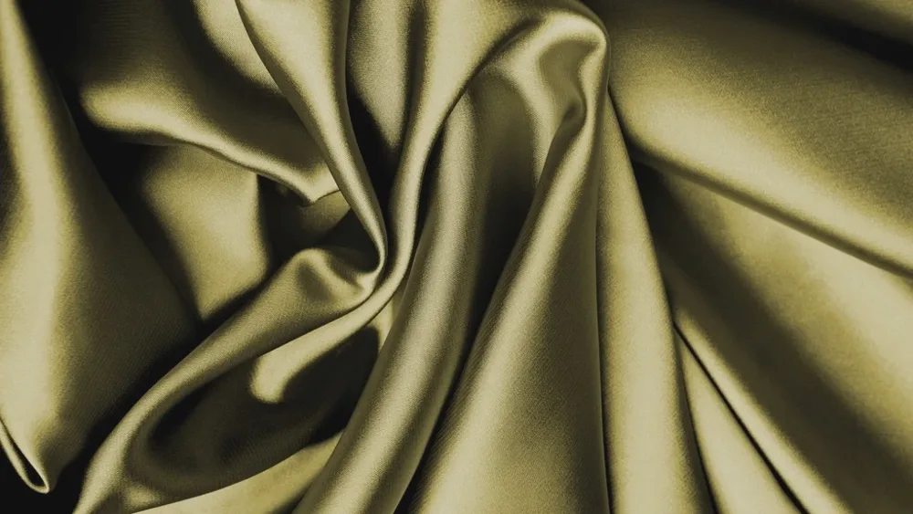 Drapé de satin vert doré aux plis souples et brillants