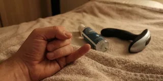 Stimulateur de prostate courbé posé sur un fond neutre