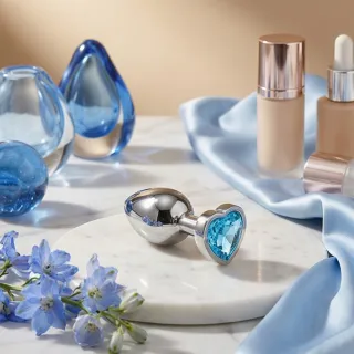 Chapelet de perles anales en silicone doux posé sur un tissu clair