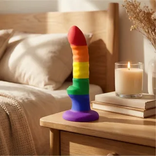 Gode-ceinture en silicone et stimulateur clitoridien posés sur un tissu clair