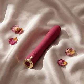 Petit vibromasseur clitoridien en silicone posé sur un drap clair