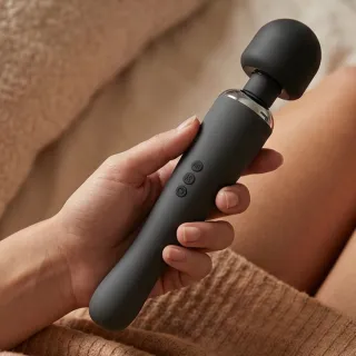 Vibromasseur wand au long manche posé sur une serviette claire