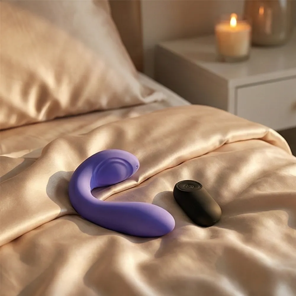 Stimulateur pour couple violet et sa télécommande sur un drap satiné