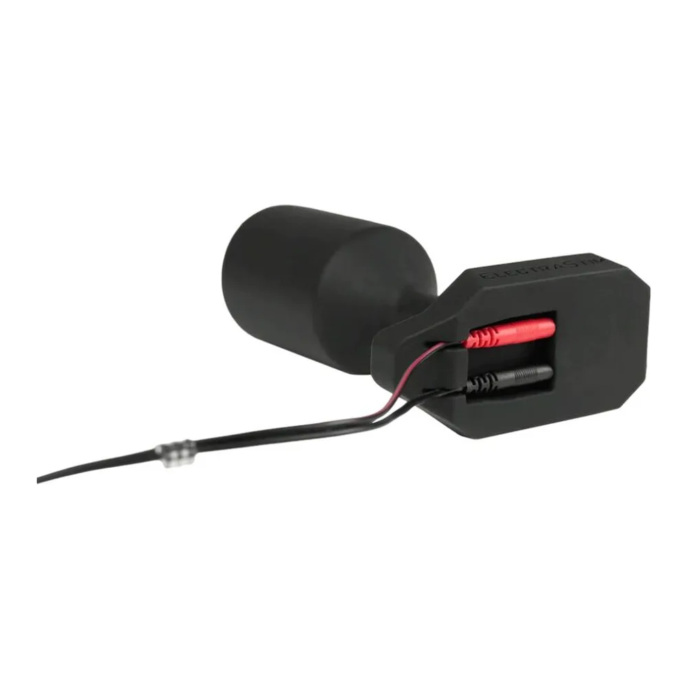 Plug anal noir en silicone avec noyau d'acier, boîtier de contrôle noir et câble de connexion rouge et noir sur fond blanc