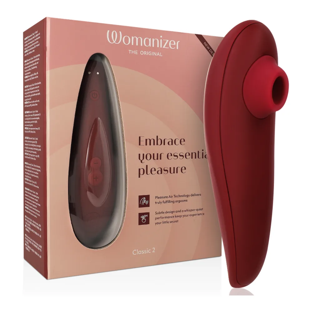 Emballage ouvert du stimulateur clitoral rose poudré avec accessoires : sachet beige, câble de recharge noir, cartes d'instructions et mode d'emploi