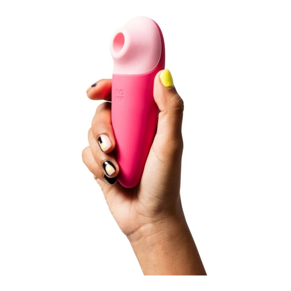 Stimulateur clitoridien rose vif de forme allongée et effilée, avec embout conique arrondi, présenté de profil sur fond blanc