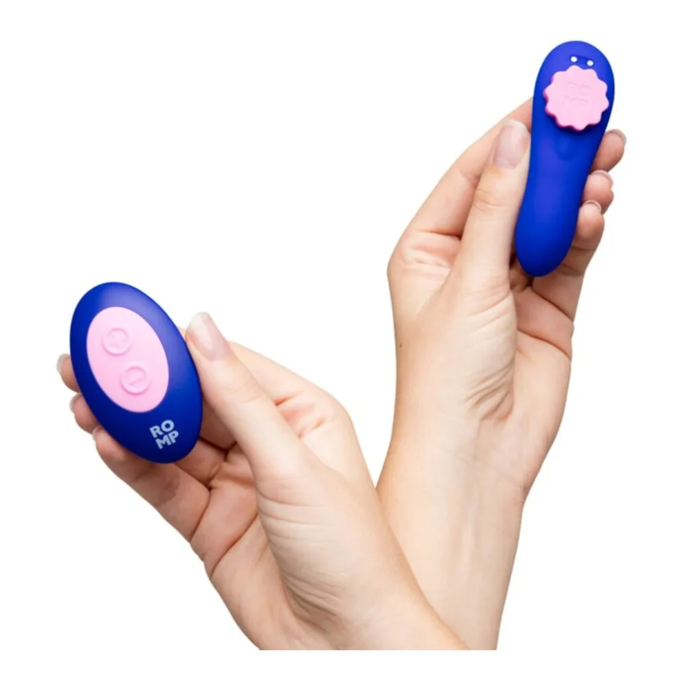 Culotte vibrante magnétique en silicone bleu vif tenue en main, avec sa télécommande rose fleur, fond blanc