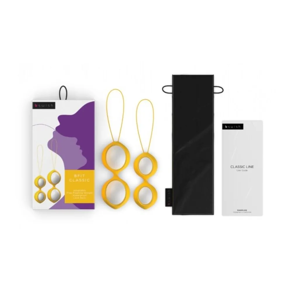 Coffret Bfit Classique contenant quatre boules de Geisha dorées de deux diamètres, deux harnais jaune or, une pochette de rangement noire et la documentation sur fond blanc