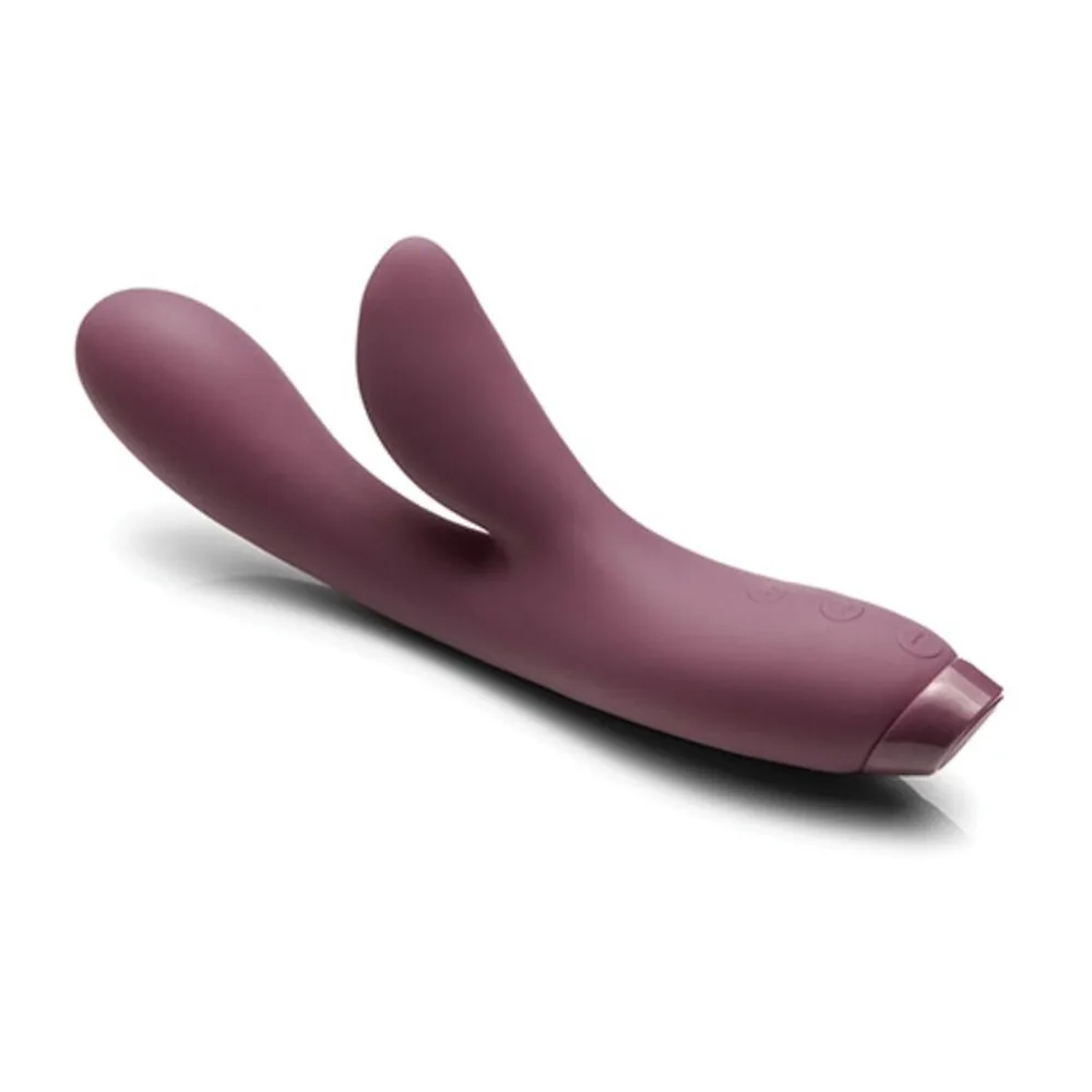 Vibromasseur rabbit en silicone aubergine, avec une tige courbe et deux bras arrondis, sur fond blanc