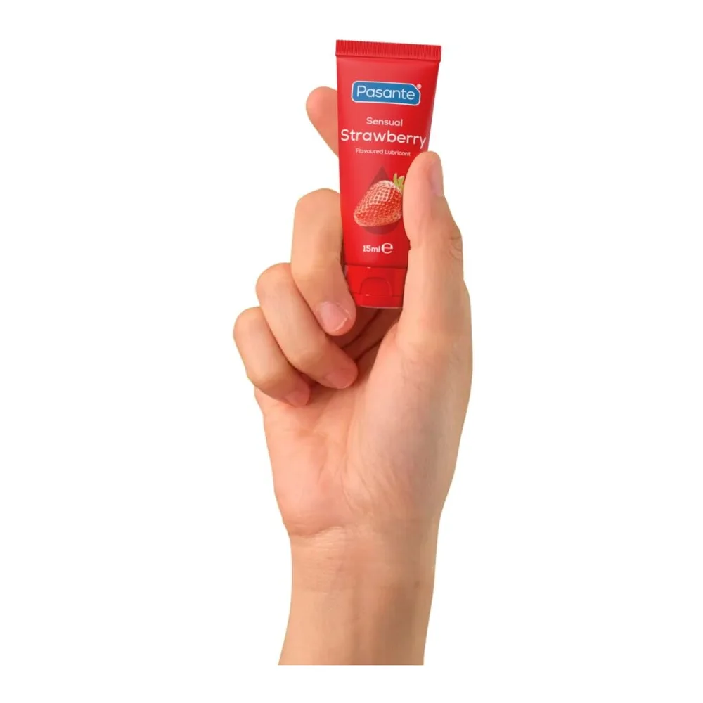 Tube de lubrifiant comestible Pasante Strawberry rouge, tenu en main sur fond blanc, emballage visible avec fraise et logo de marque