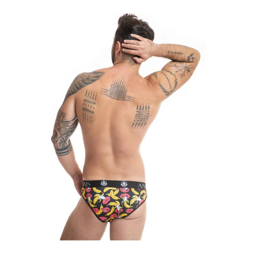 Slip échancré noir imprimé de bananes et bouches colorées, porté par un homme tatoué sur fond blanc