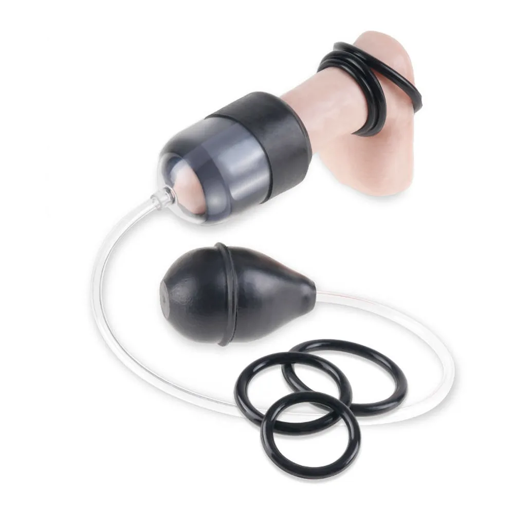 Pompe à pénis noire en silicone avec tube transparent, composée d'un cylindre de stimulation du gland et d'une poire d'aspiration, accompagnée d'un anneau de maintien noir détaché