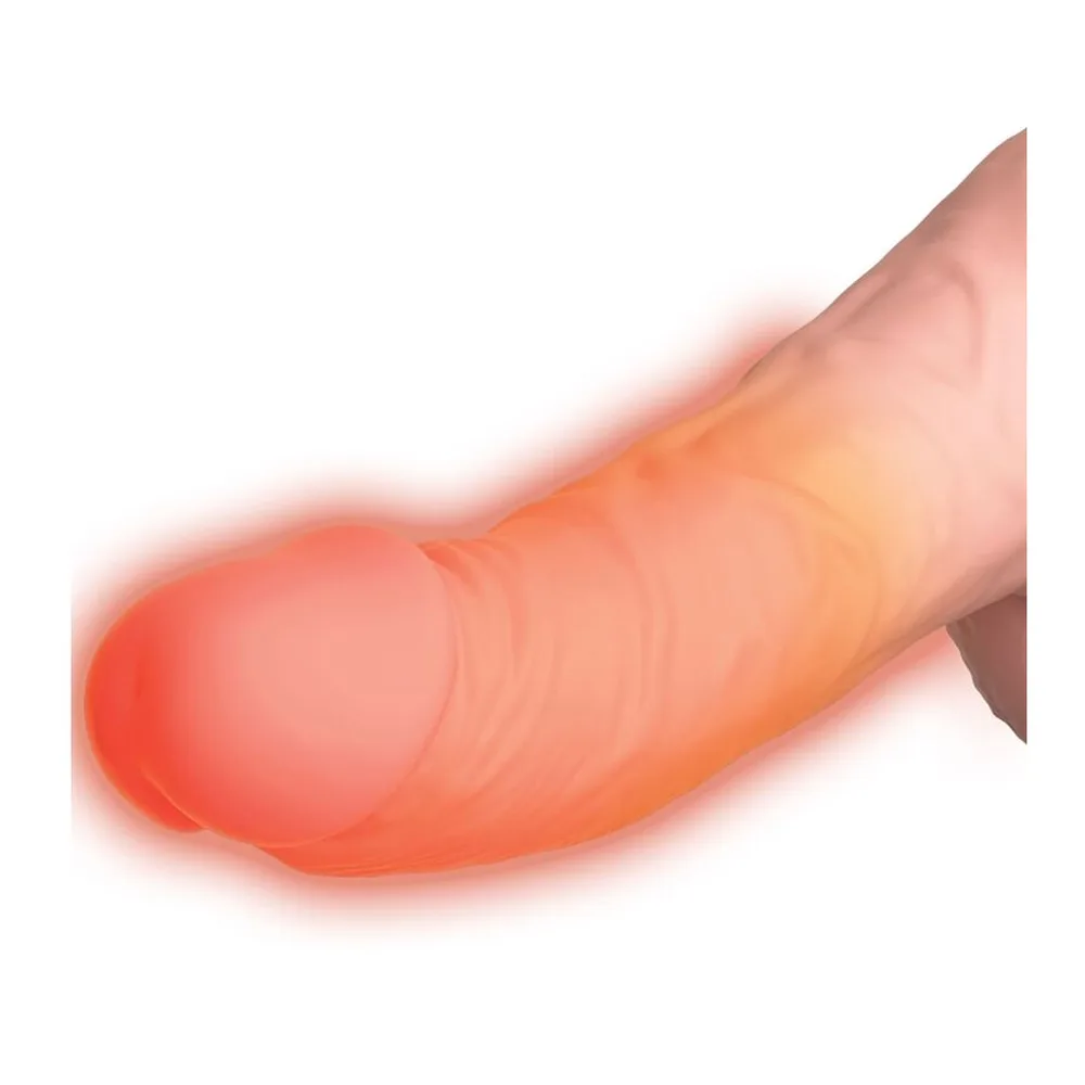 Vibromasseur réaliste en silicone rose clair, gland bombé et texturé, base avec testicules, sur fond blanc