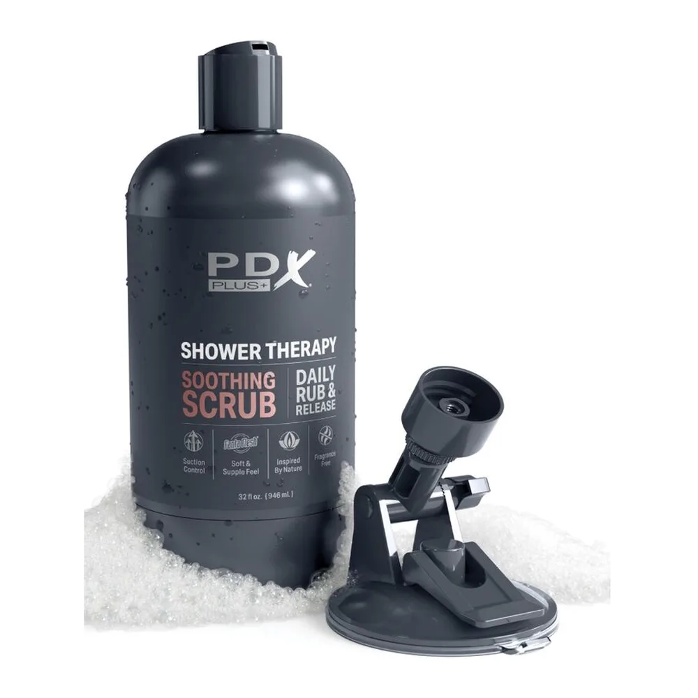 Masturbateur stroker noir fixé à une ventouse sur carrelage blanc, avec étiquette rouge "Soothing Scrub" visible sur le flacon