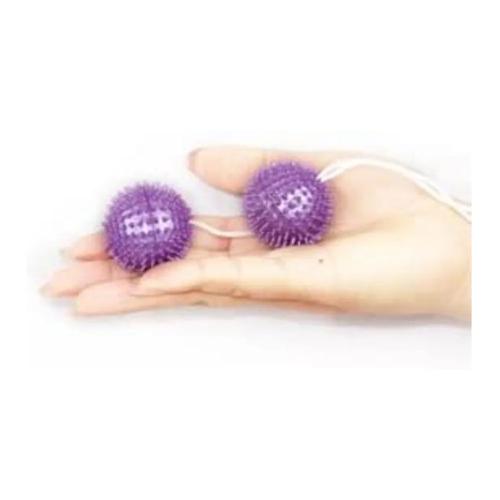 Deux boules de Geisha rose vif en silicone, couvertes de picots, reliées par une ficelle blanche de retrait sur fond blanc