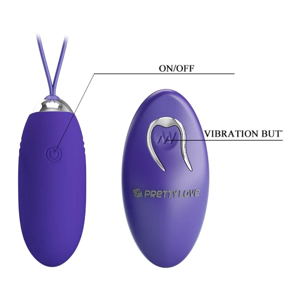 Œuf vibrant violet avec cordon de suspension, câble USB de recharge blanche et télécommande violette avec pile AAA visible dans son emballage