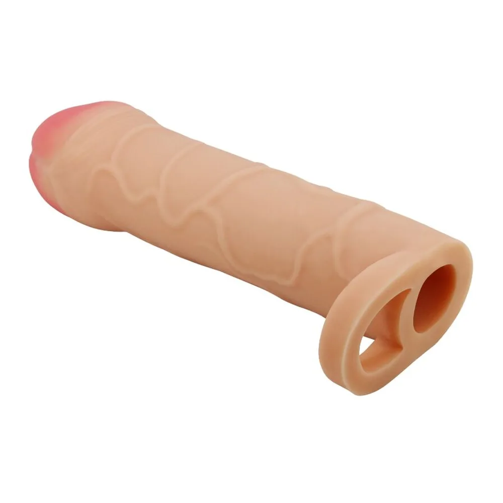 Gaine de pénis en silicone chair avec sommet rose pâle, reliée à un anneau testiculaire, sur fond blanc