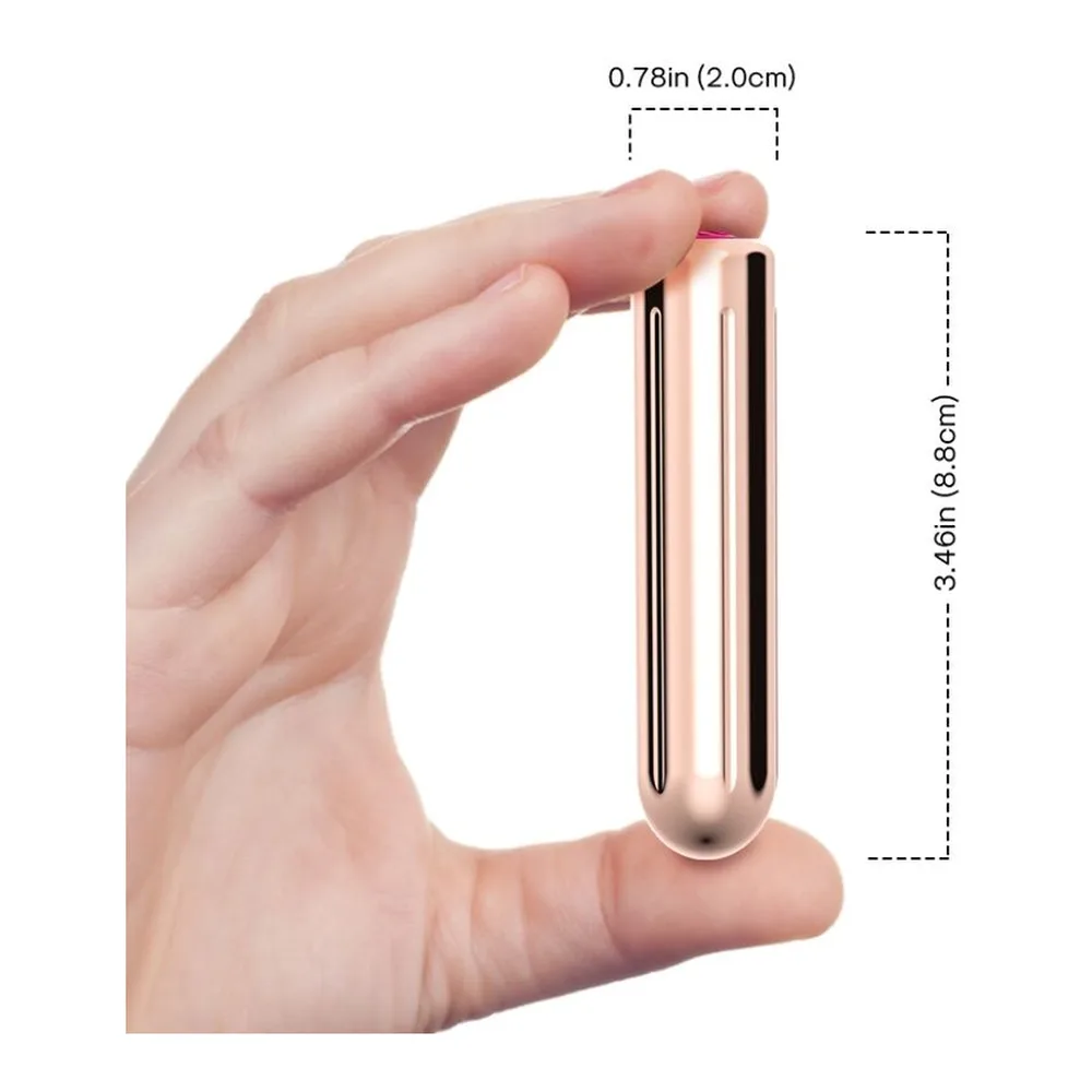 Bullet vibrant métallisé rose poudré de 8,8 cm, présenté à côté de son emballage blanc à motifs ondulés avec branding noir et visuel coloré de performance en bas