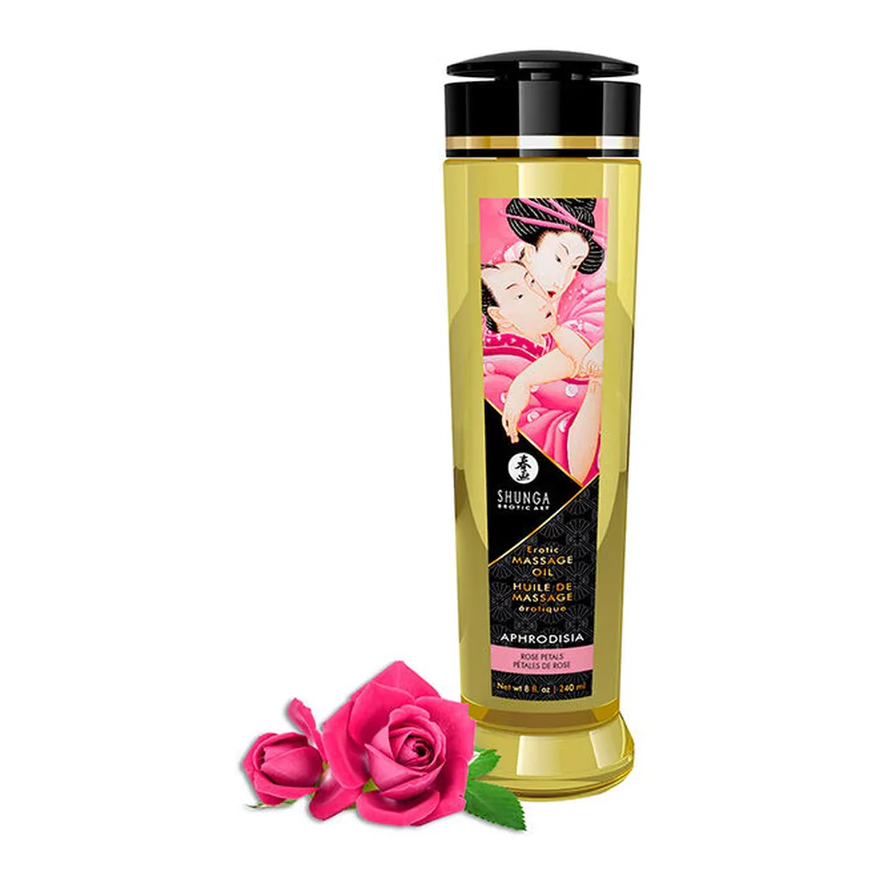 Flacon de 240 ml d'huile de massage transparent jaune paille à bouchon noir doré, étiquette ornée d'une illustration rose et noire, posé devant deux roses roses