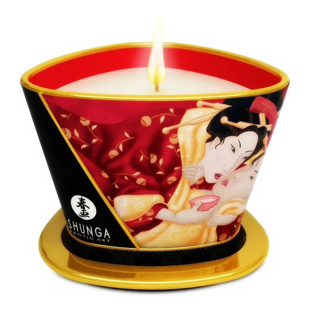 Bougie de massage dans un récipient en porcelaine rouge et noir décorée d'un motif asiatique, reposant sur un socle doré, avec mèche jaune allumée