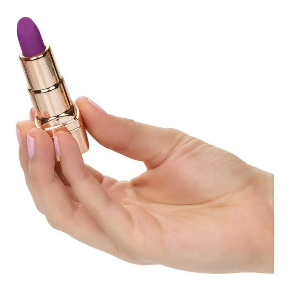 Stimulateur clitoridien rechargeable déguisé en rouge à lèvres doré avec embout violet, présenté avec son capuchon gravé Bad Bitch