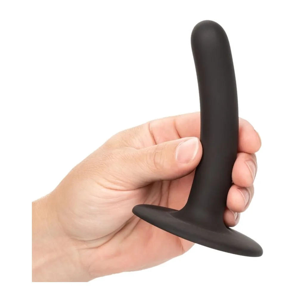 Gode en silicone noir mat, tige inclinée et effilée terminée par un gland arrondi, monté sur une base plate circulaire, fond blanc