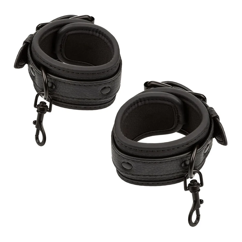 Quatre bracelets de cuir noir texturisé avec clous, reliés par une bande centrale en cuir croisée, formant un système de retenue réglable avec chaînes et boucles métalliques