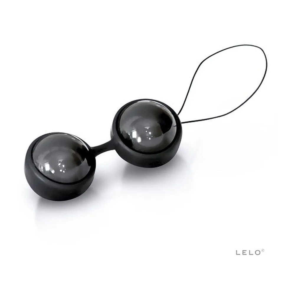 Paire de boules de Geisha en silicone noir brillant de 29 mm, reliées par un connecteur souple et une cordelette de retrait blanche, sur fond blanc