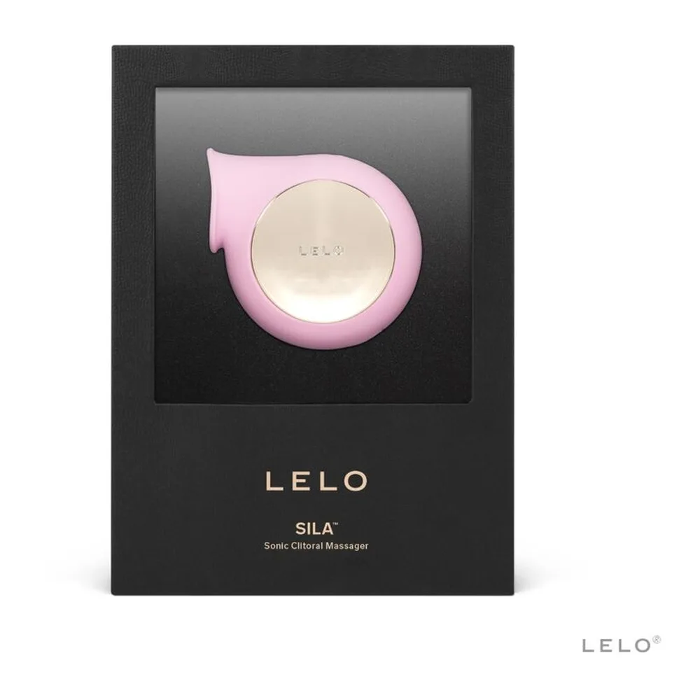 Emballage ouvert du stimulateur clitoridien Sila rose avec sa housse de rangement noire, le câble USB de recharge blanc et la carte de garantie