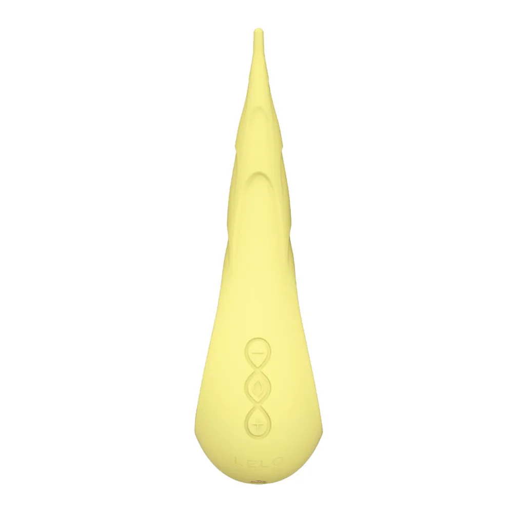 Stimulateur clitoridien en silicone jaune pâle, forme allongée pointue, embout noir métallisé, motifs gravés en relief, fond blanc