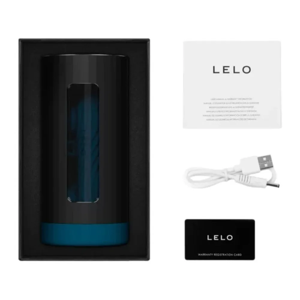Emballage ouvert du masturbateur F1s V3 XL noir avec insert bleu, accompagné du livret LELO, du câble USB blanc et de la carte de garantie