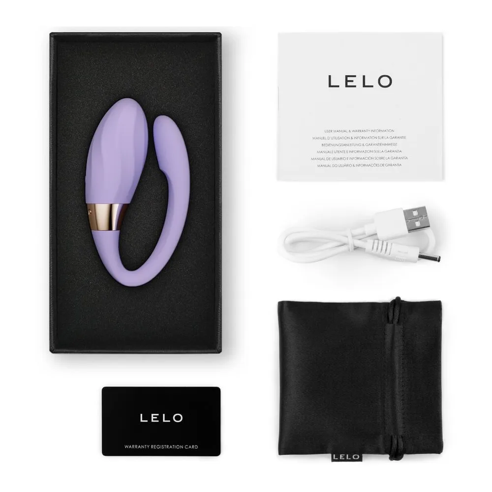Stimulateur clitoridien en silicone violet clair, design courbe épousant deux zones, anneau doré avec logo au centre