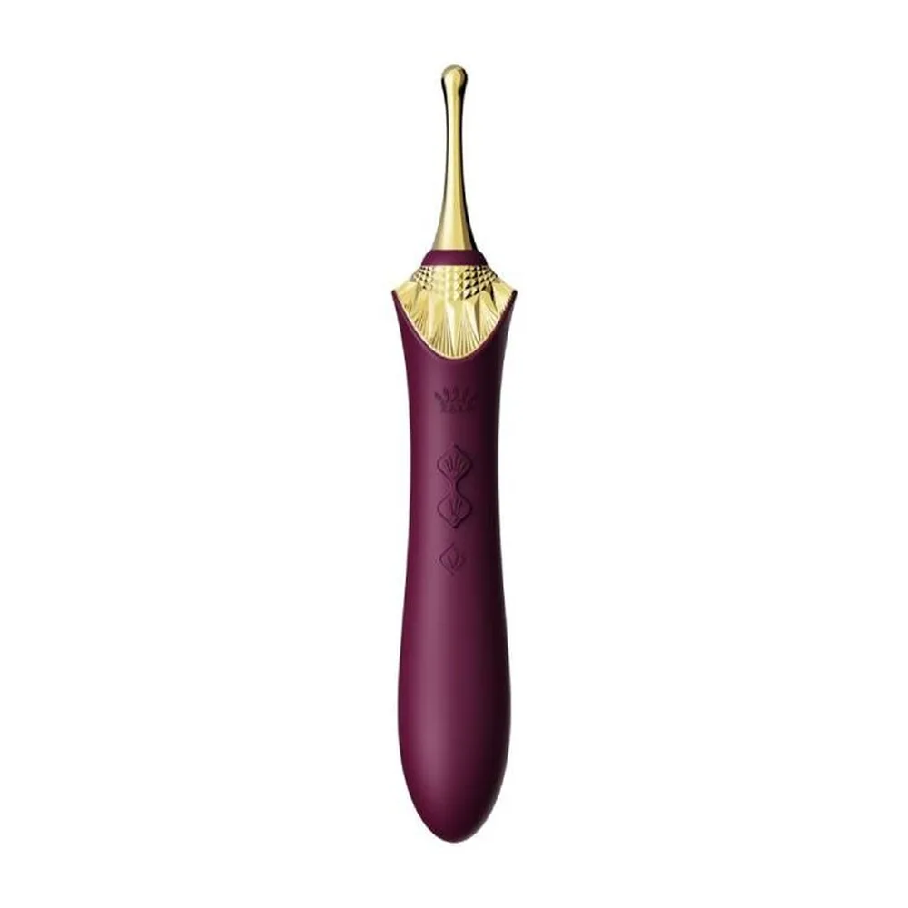 Stimulateur clitoridien violet aubergine avec embout doré en forme de coquille Saint-Jacques, manche lisse orné de motifs géométriques discrets, sur fond blanc