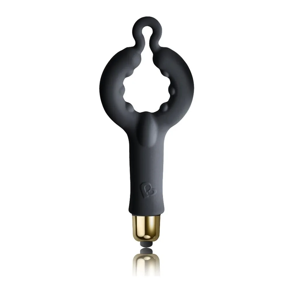 Plug anal noir en silicone tenu en main, avec embout doré, forme effilée et anneau de préhension, sur fond blanc