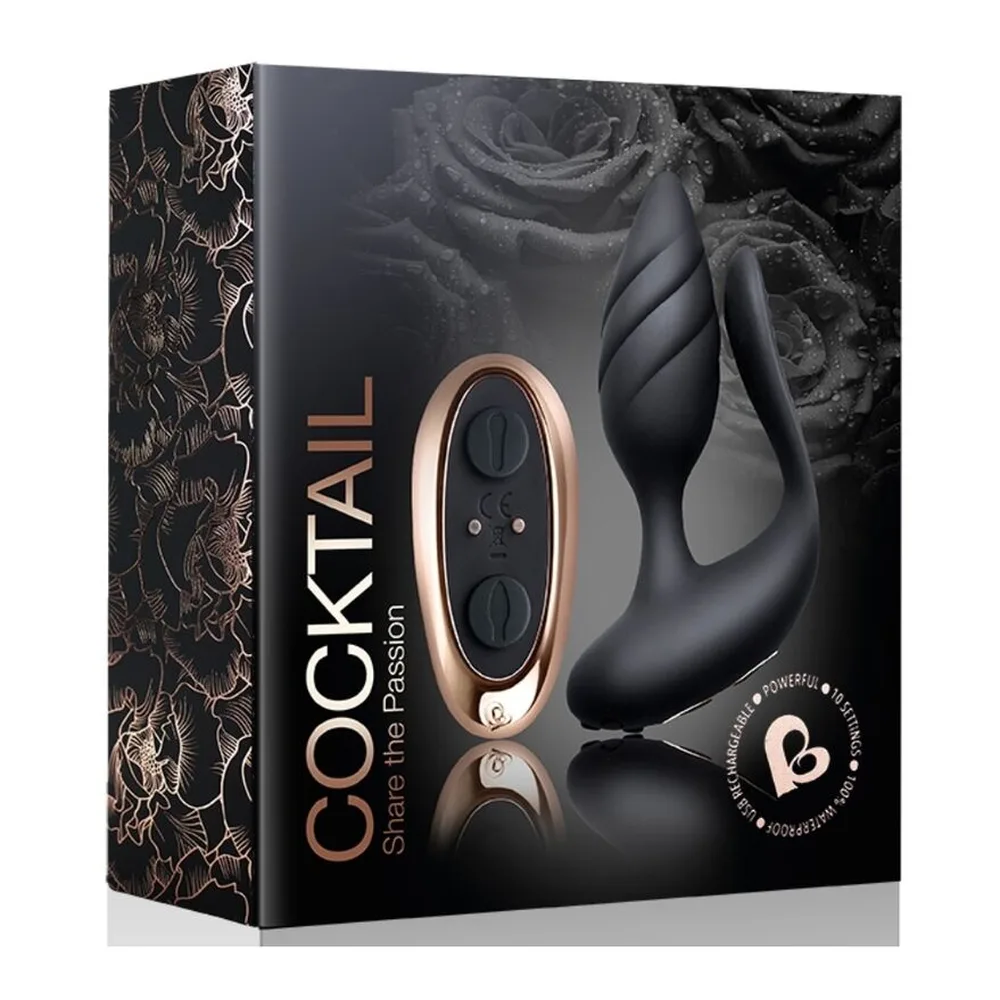 Stimulateur noir en silicone avec deux branches tenu dans une main, présentant des surfaces texturées et une forme ergonomique