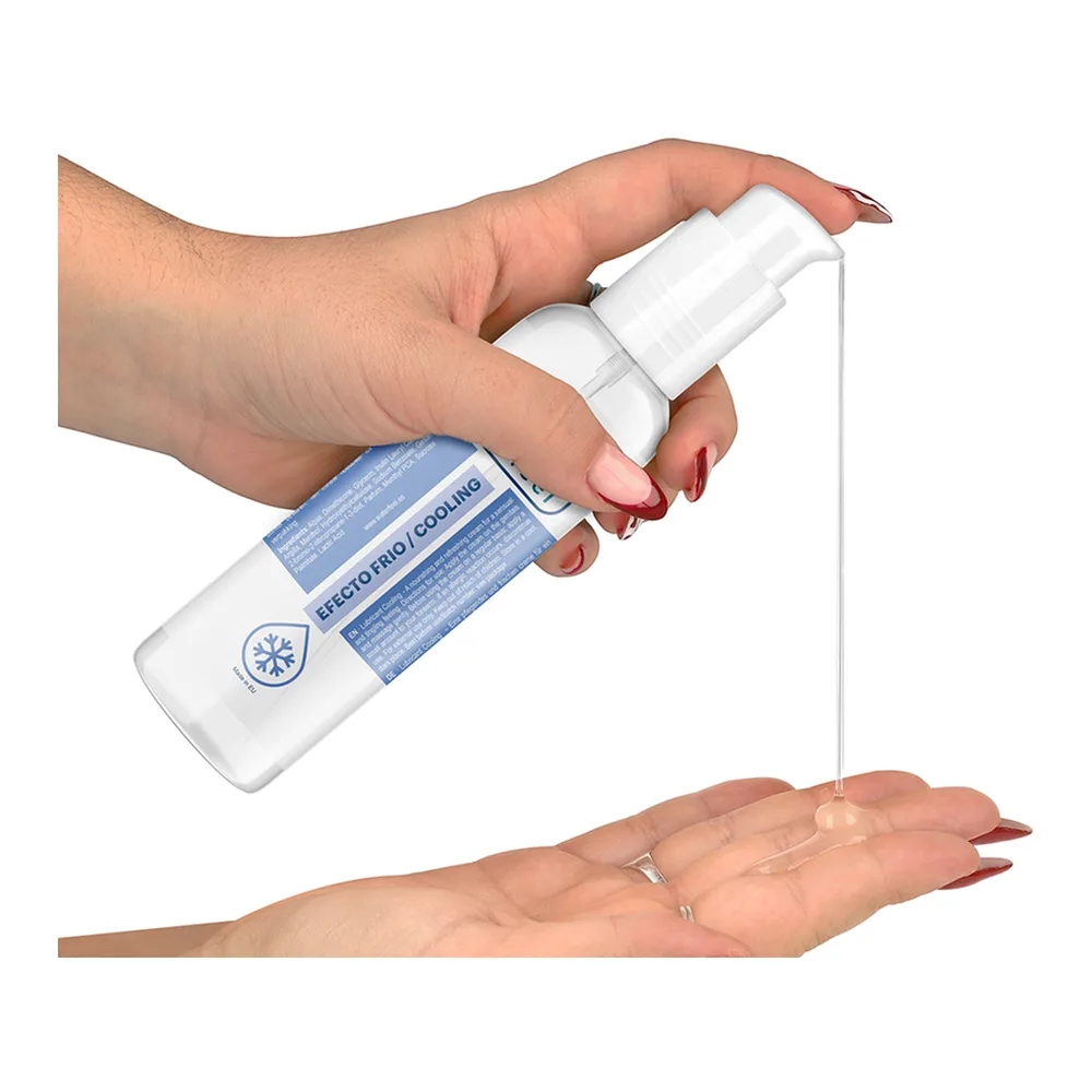 Flacon blanc et bleu de lubrifiant avec applicateur, versé dans la paume d'une main sur fond blanc