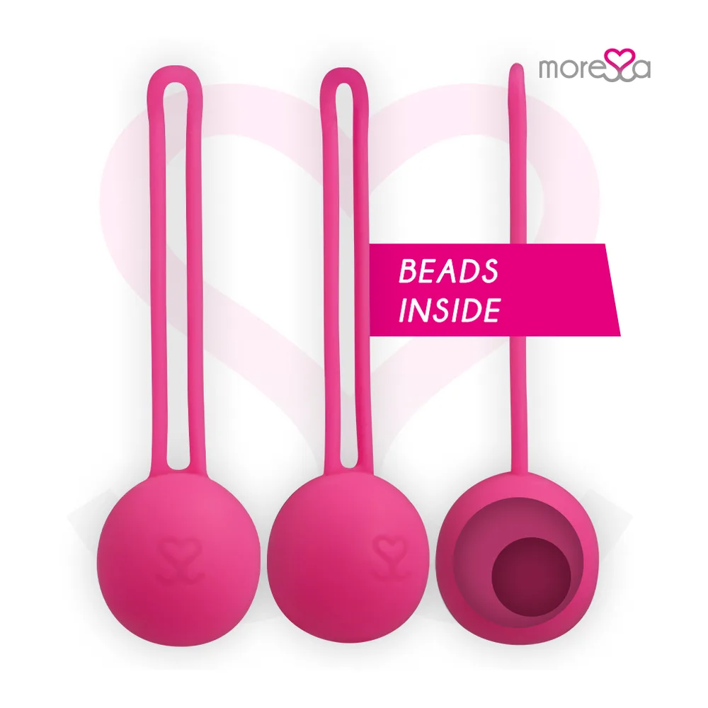 Main tenant une boule de Geisha rose fuchsia en silicone par sa cordelette, sur fond avec cœur rose et logo de marque