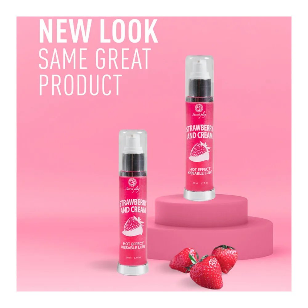 Flacon spray rose de lubrifiant 2-en-1 effet chaleur fraise crème, tenu en main, avec étiquette blanche et bouchon pulvérisateur argenté