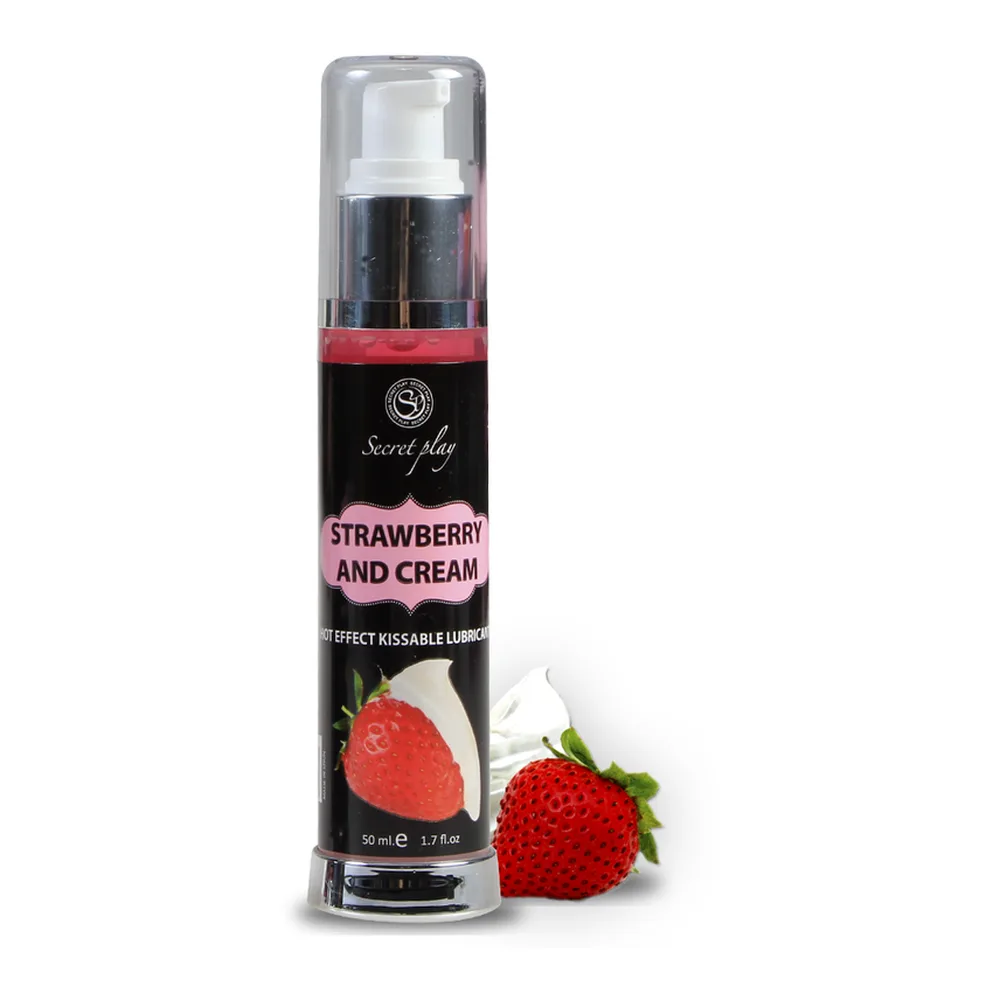 Flacon spray rose de lubrifiant 2-en-1 effet chaleur fraise crème, tenu en main, avec étiquette blanche et bouchon pulvérisateur argenté