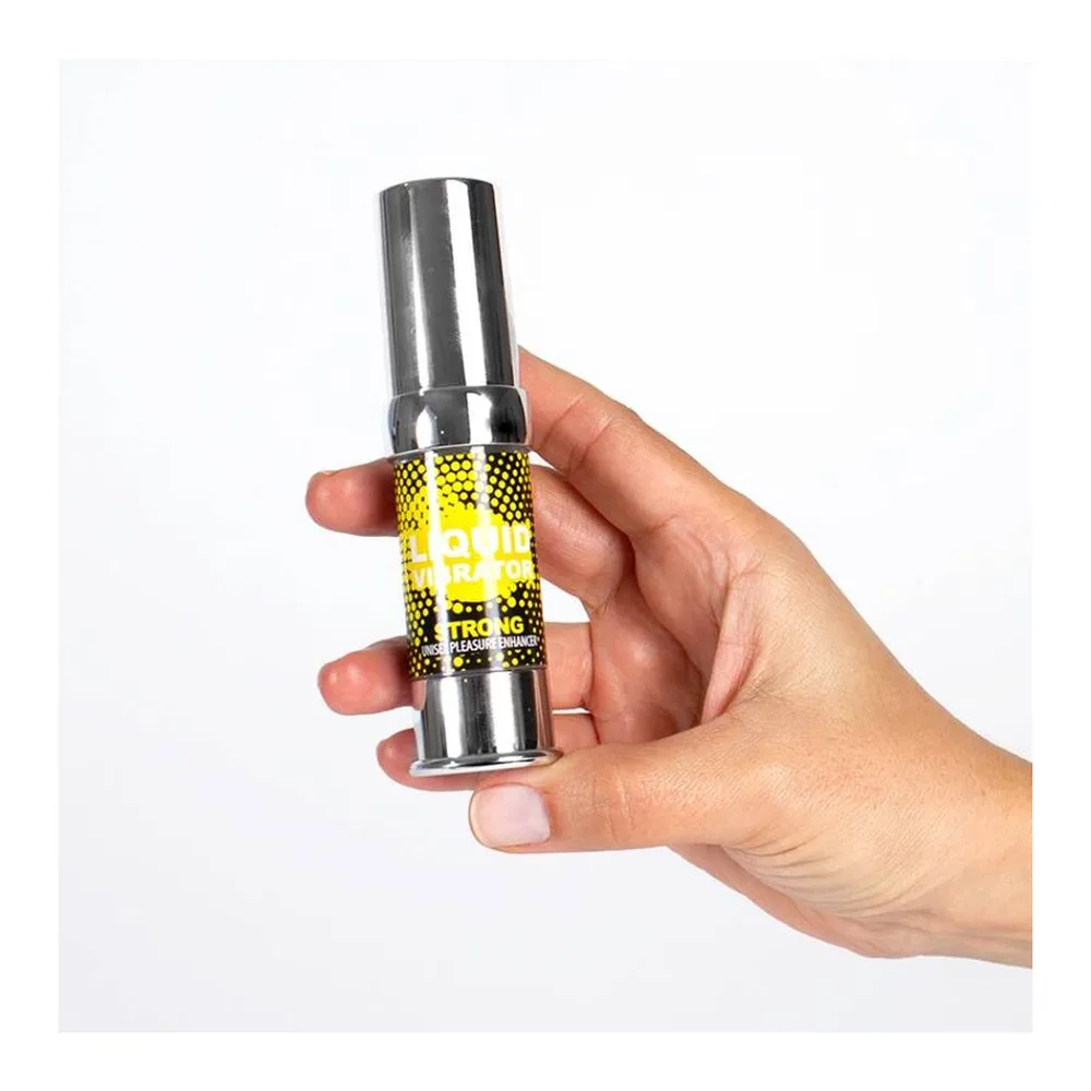 Petit flacon de gel jaune à étiquette noire et dorée, fermé par un capuchon gris métallisé, tenu en main sur fond blanc