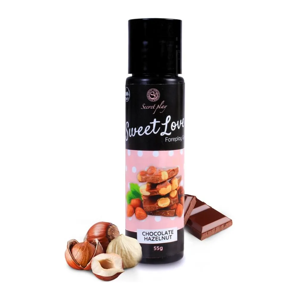Flacon airless noir de gel comestible Sweet Love saveur chocolat-noisette, 55g, entouré de noisettes décortiquées et de carrés de chocolat sur fond blanc