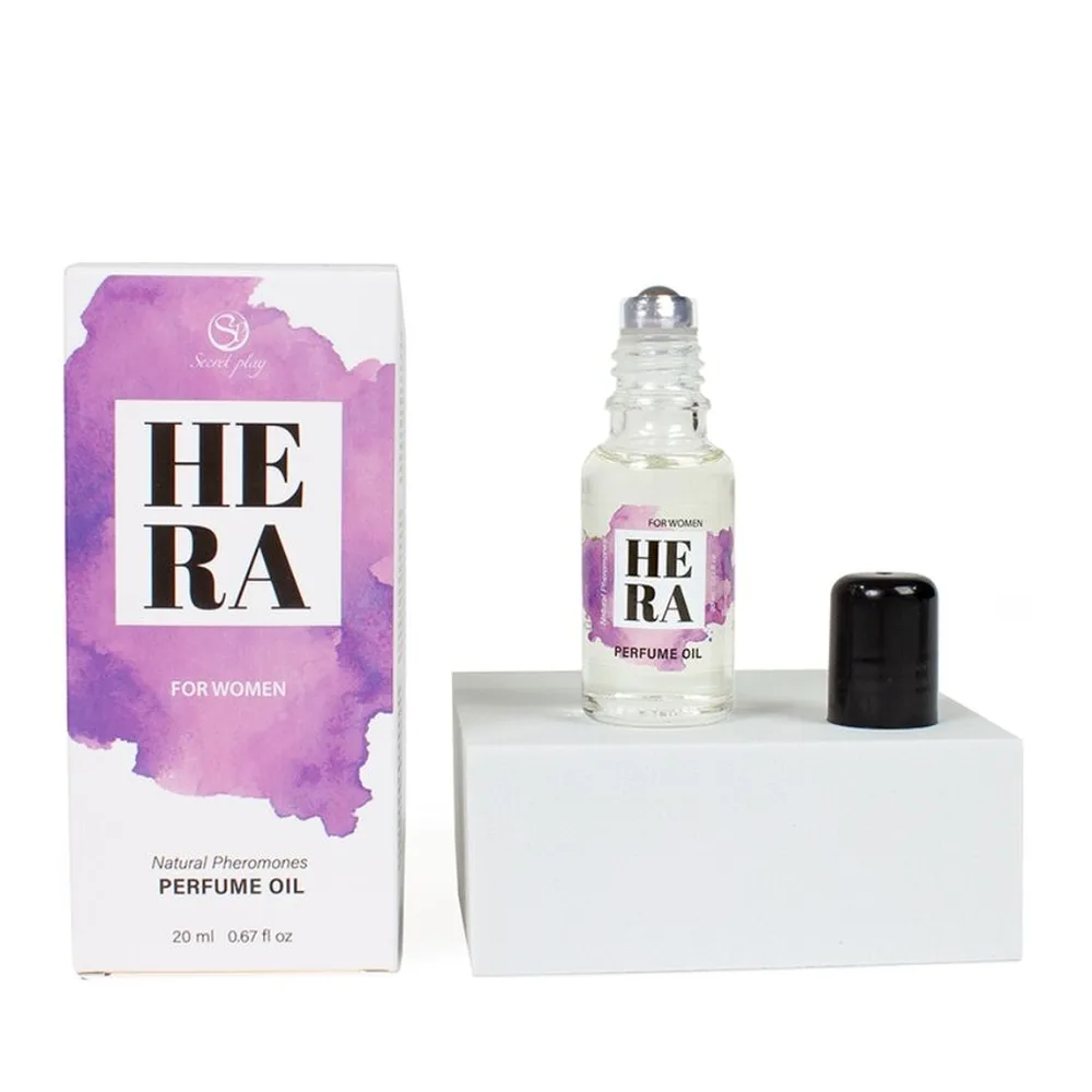 Boîte violette et blanche du parfum Hera avec flacon roll-on transparent contenant une huile parfumée incolore, bouchon noir, présenté sur socle blanc avec emballage