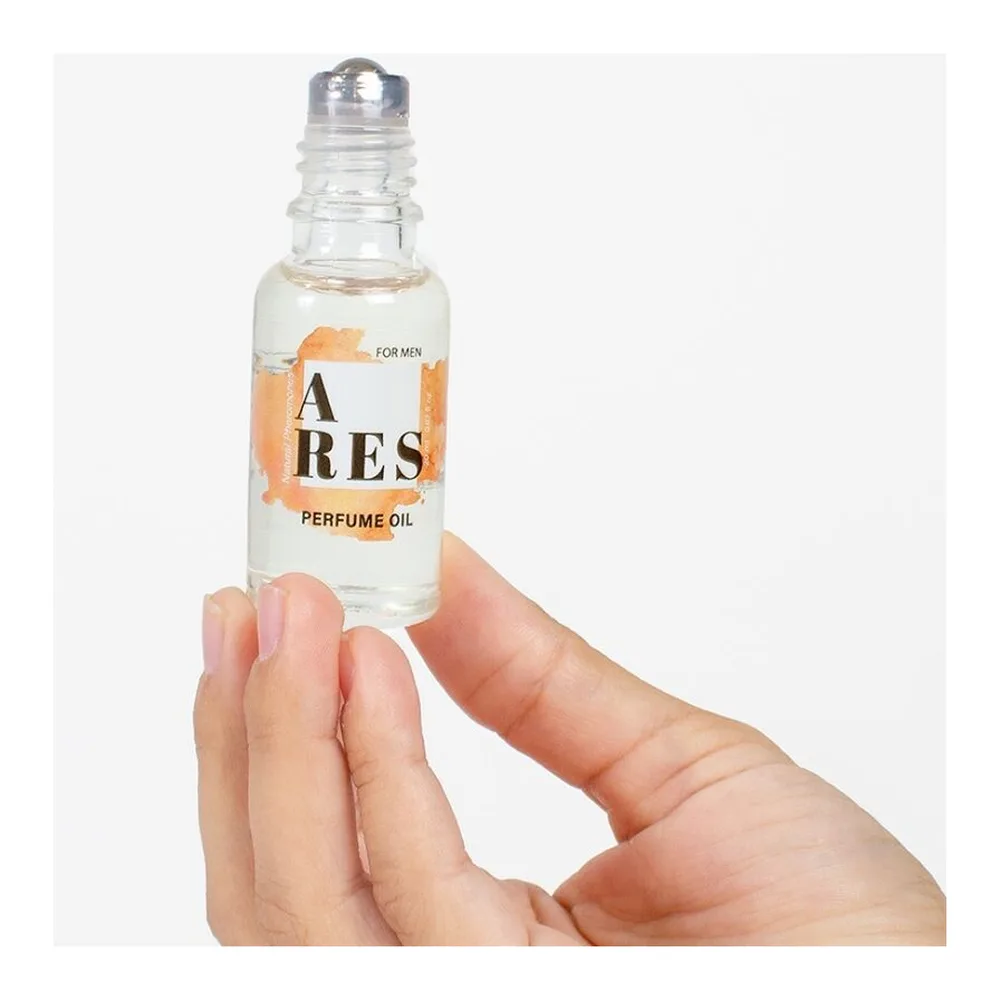 Boîte orange et blanche avec logo ARES et flacon roll-on transparent contenant une huile parfumée incolore, capuchon noir, présenté sur socle blanc