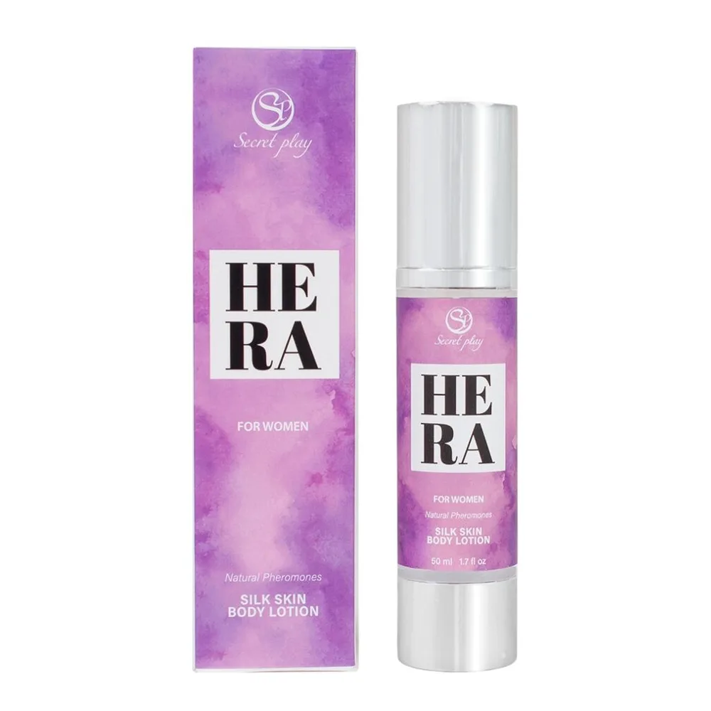 Flacon de lotion corporelle Hera Silk Lotion en spray avec capuchon argenté, étiquette rose vif, tenu en main sur fond blanc