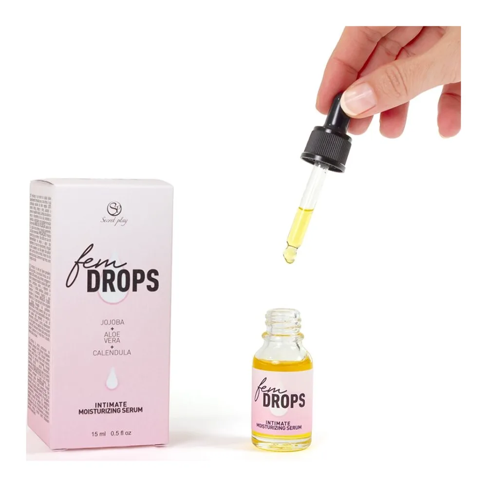 Pipette compte-gouttes avec capuchon noir tenue par une main, contenant un sérum huileux jaune clair sur fond blanc