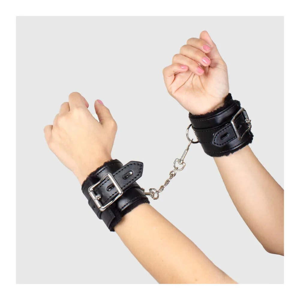 Emballage noir allongé de menottes bondage avec illustration rose d'une silhouette, contenant une paire de menottes métalliques noires visibles dans la boîte ouverte