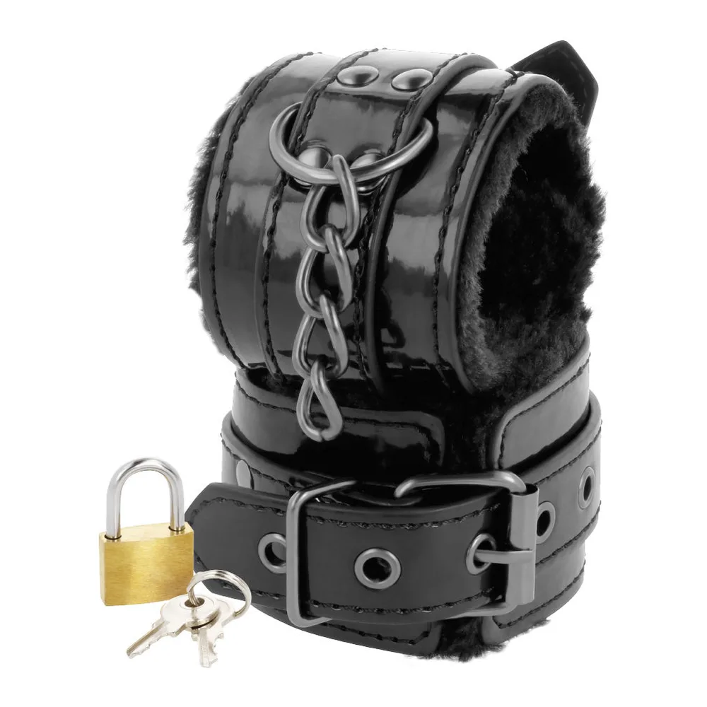 Menottes de poignets en cuir noir avec doublure en fourrure, chaîne métallique et cadenas laiton avec deux clés, sur fond blanc